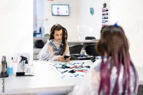 Tableau sur toile little girl dyes her hair purple in a hairdressing salon