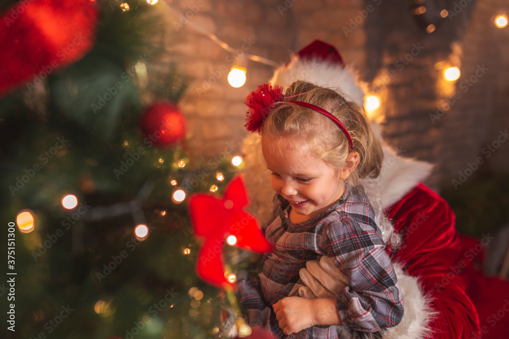 Little girl and Santa decorating Christmas tree Little girl and Santa decorating Christmas tree