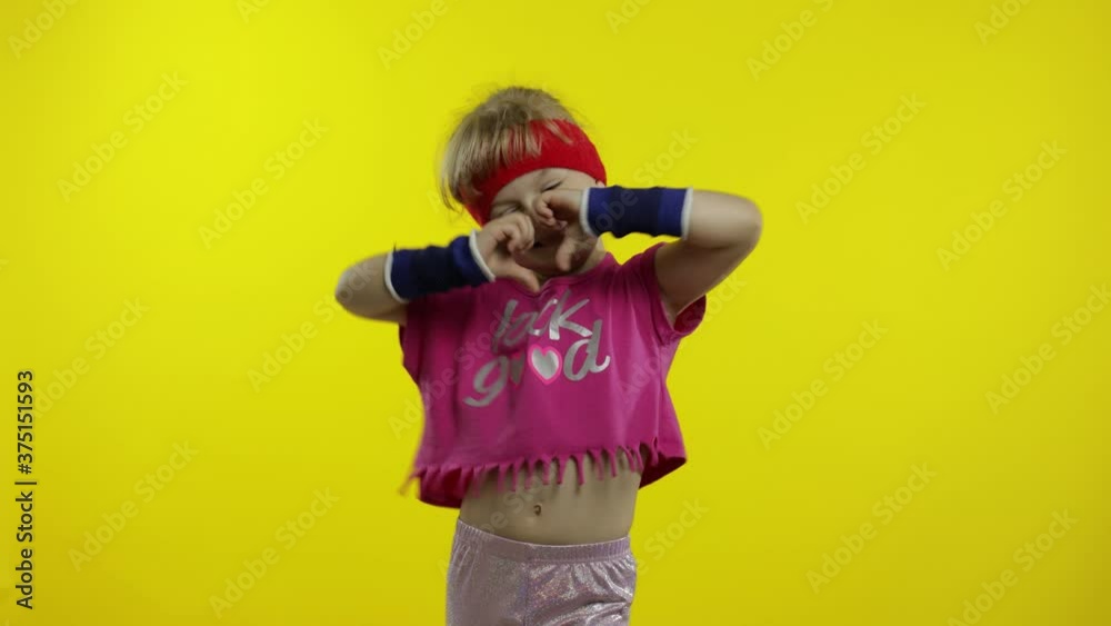 Little energetic caucasian girl in pink sportswear making fit dance, modern aerobic dancer Little energetic caucasian girl in pink sportswear making fit dance, modern aerobic dancer