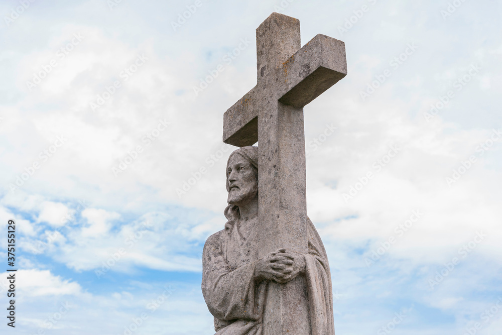 The statue of Jesus Christ with cross. Cloudy sky on background. (concept Christianity) The statue of Jesus Christ with cross. Cloudy sky on background. (concept Christianity)