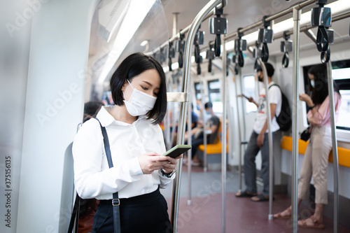 Young Asian female passengers wear a mask in a subway train when traveling in big city at Covid19 outbreak.