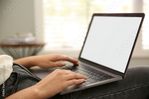 Woman working with modern laptop indoors, closeup