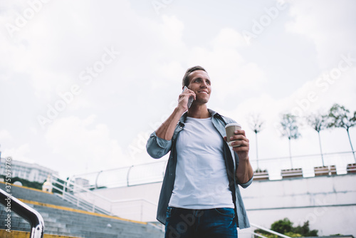 Cheerful man talking on smartphone in city