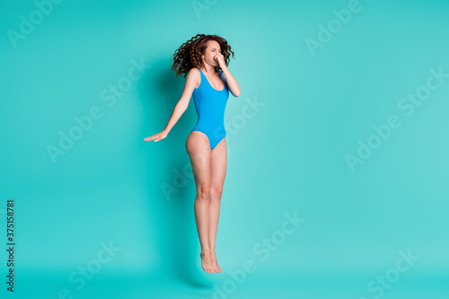 Full body profile side photo of thin shape figure girl jump up dive springboard underwater hold breath touch hand nose wear blue bodysuit isolated over teal color background photo