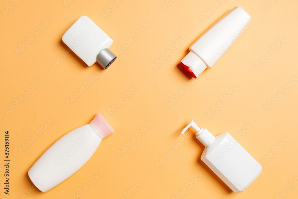 Set of White Cosmetic containers isolated on colored background, top view with copy space. Group of plastic bodycare bottle containers with empty space for you design Set of White Cosmetic containers isolated on colored background, top view with copy space. Group of plastic bodycare bottle containers with empty space for you design