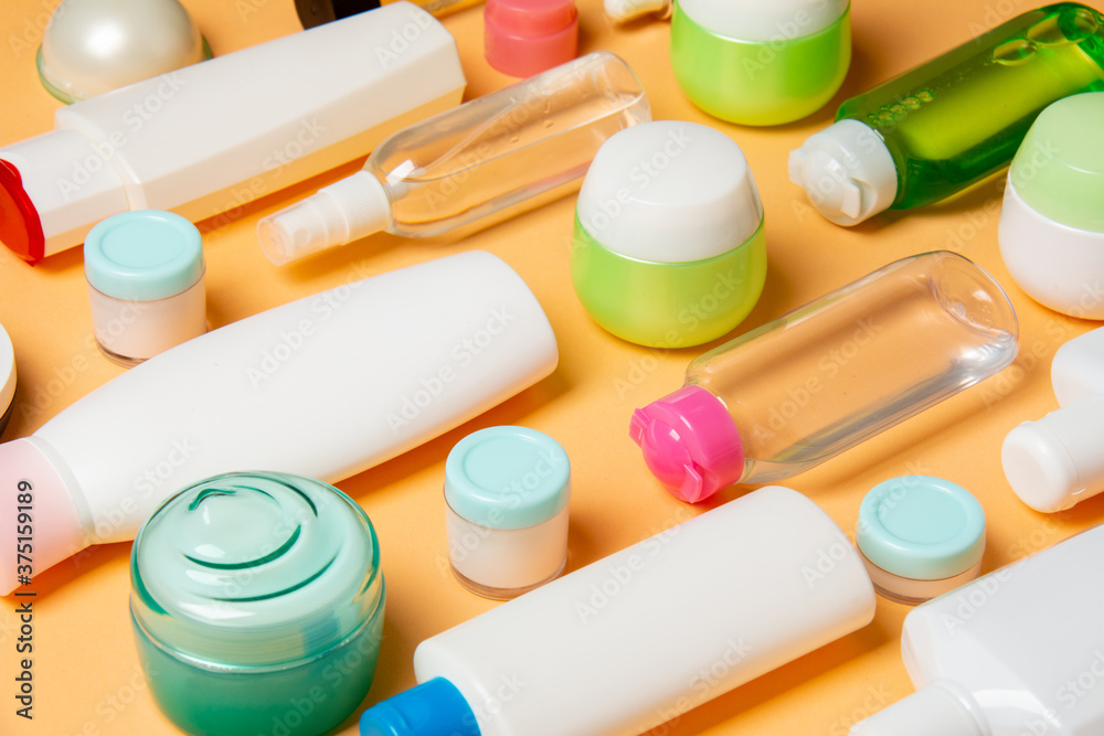 Top view of different cosmetic bottles and container for cosmetics on colored background. Flat lay composition with copy space Top view of different cosmetic bottles and container for cosmetics on colored background. Flat lay composition with copy space