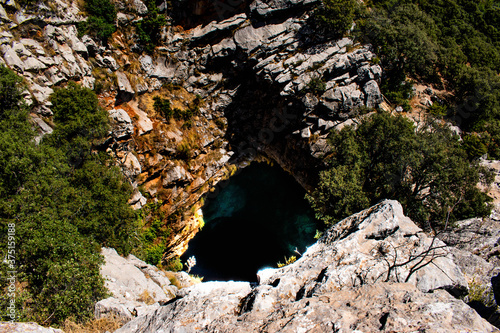 Friouato cave hole seen from the top of the cliff, the biggest chasm in North Africa giving access to an underground network of caves, lakes, rivers, wells, galleries, and multicolor rocks photo