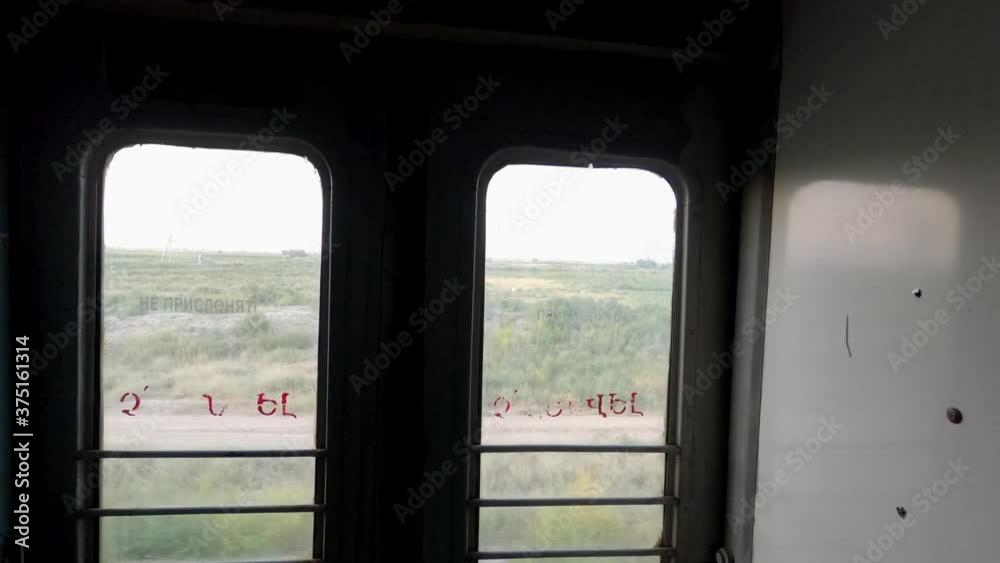 Interior passenger, railway train.Camera show window in corridor, then slowly move and show inscription no smoking in Russian. Old train.
