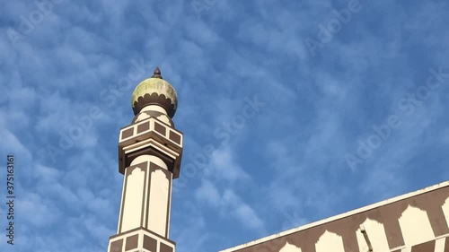 A bird flies on top of a mosque against a beautiful blue sky background photo