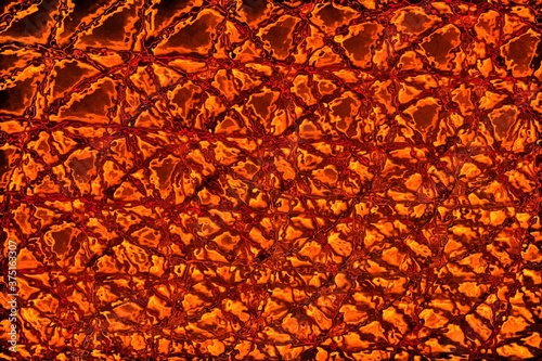 Abstract fire background or Christmas orange paper. Glowing shiny magic shapes