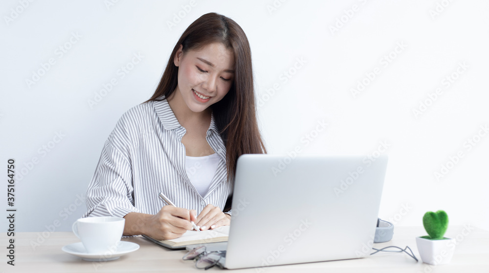Young Asian woman works on paperwork in her own home online. Young Asian woman works on paperwork in her own home online.
