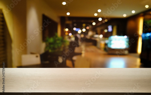 Empty dark wooden table in front of abstract blurred bokeh background of restaurant . can be used for display or montage your products.Mock up for space.