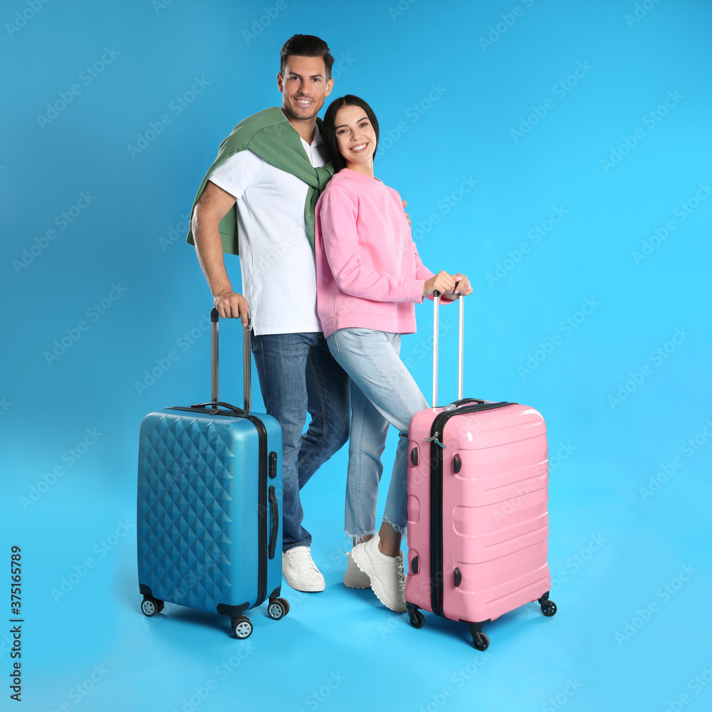 Happy couple with suitcases for summer trip on blue background. Vacation travel Happy couple with suitcases for summer trip on blue background. Vacation travel