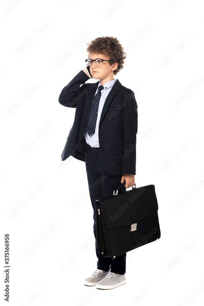curly boy in suit and glasses holding briefcase while talking on smartphone isolated on white curly boy in suit and glasses holding briefcase while talking on smartphone isolated on white