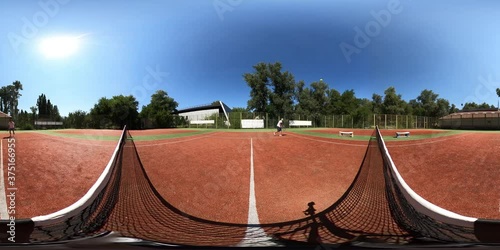 Distant men playing tennis on court together