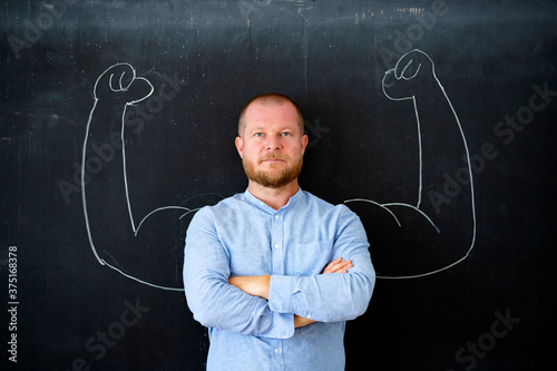Successful self confident businessman with fake muscles made of chalk.
