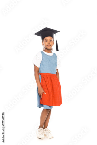 african american kid in graduation cap standing isolated on white