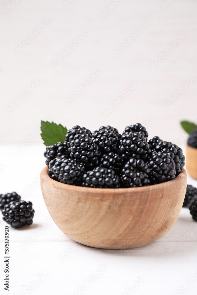 Fresh ripe blackberries in bowl on white wooden table. Space for text Fresh ripe blackberries in bowl on white wooden table. Space for text