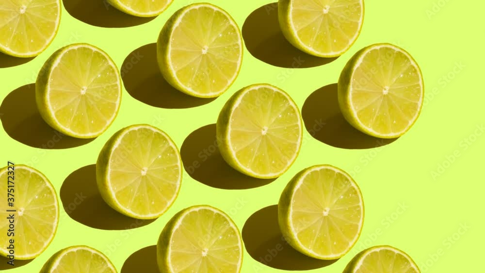 Stop Motion Cut and whole green limes move from left to right on a green background Stop Motion Cut and whole green limes move from left to right on a green background