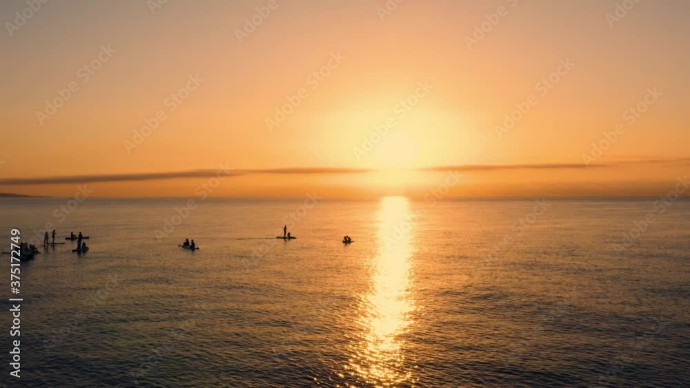 Silhouette di persone che fanno Stand up Paddle o sup, un sport che si svolge su una tavola da surf alzati all'alba sul Mare. Silhouette di persone che fanno Stand up Paddle o sup, un sport che si svolge su una tavola da surf alzati all'alba sul Mare.