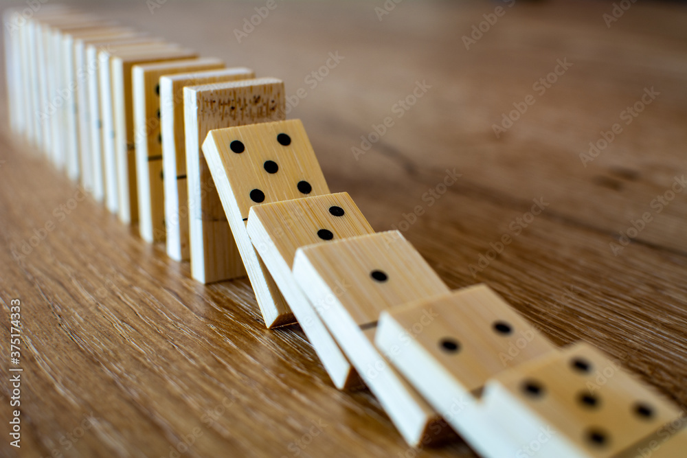 Falling dominoes on wooden table