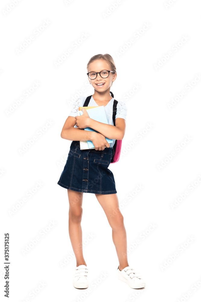 schoolkid in glasses holding books while standing and looking at camera isolated on white schoolkid in glasses holding books while standing and looking at camera isolated on white