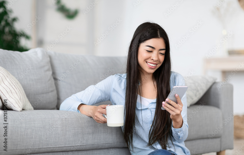 Positive Korean Girl Texting On Smartphone And Enjoying Morning Coffee At Home Positive Korean Girl Texting On Smartphone And Enjoying Morning Coffee At Home