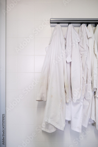 Dirty lab coats hanging in a laboratory. Research concept. © Ladanifer