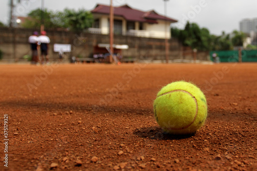 Close up of tennis ball on clay court. Tennis ball on a tennis clay court