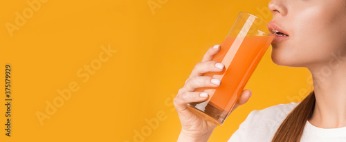 Tela Unrecognizable woman drinking orange or carrot fresh vitamin juice