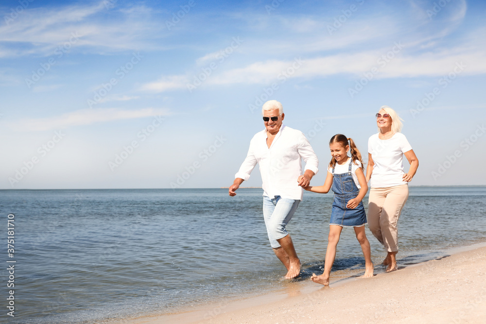 Cute little girl with grandparents spending time together on sea beach Cute little girl with grandparents spending time together on sea beach