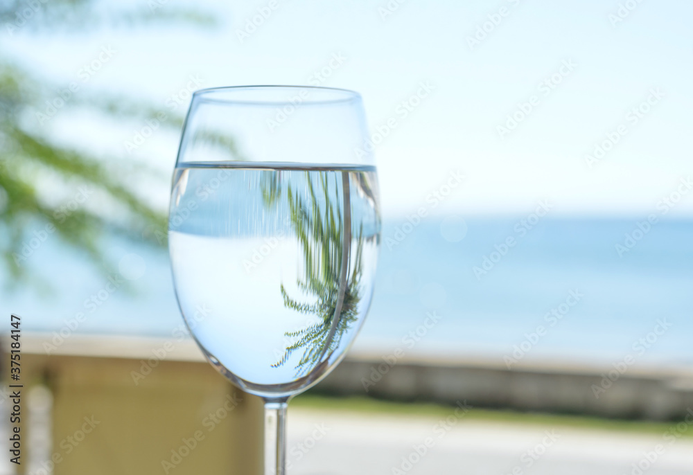 Obraz premium a glass of clear and pure water on the background of the sea