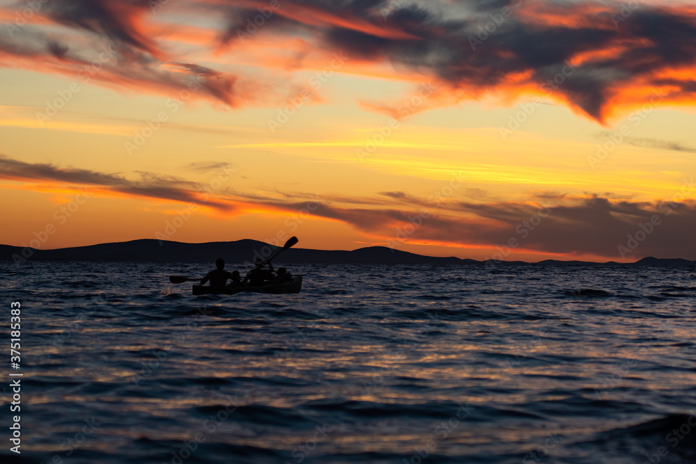 ZADAR, CROATIA, summer 2020. Silhouette of people kayaking into the colorful sunset at the Adriatic sea