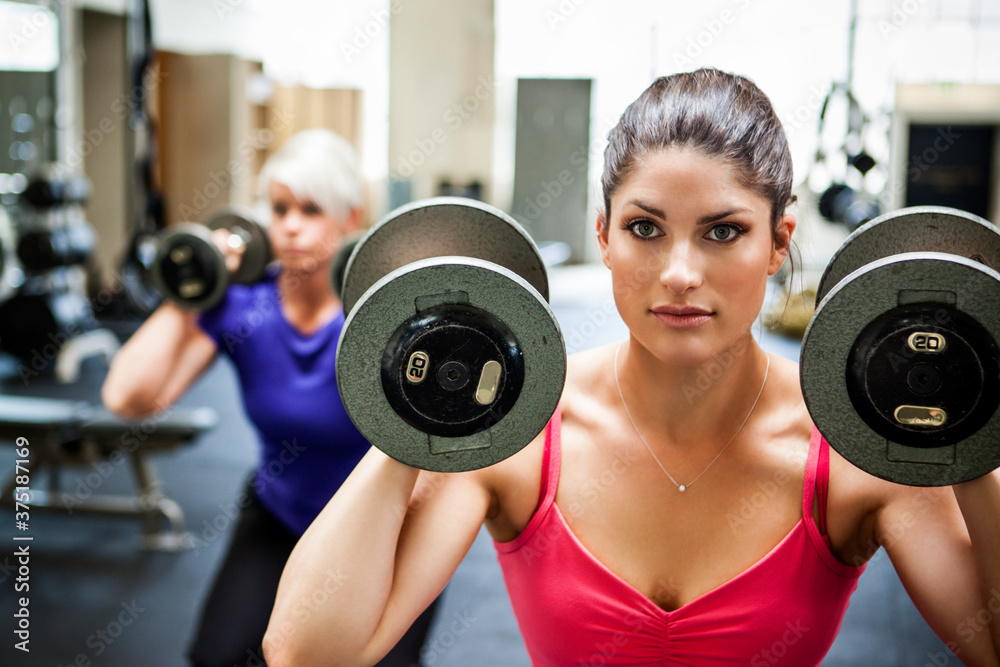Personal trainer training her client in the gym