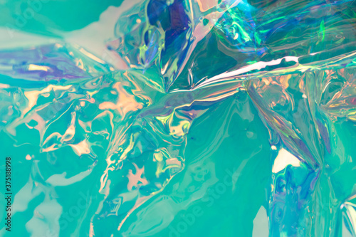 Mint colored holographic background. Wrinkled foil surface. Soft focus abstract backdrop. photo