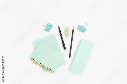 Mint color stationery on a white table. Office supplies layout.