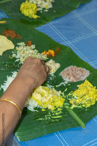 Traditional Kerala food being eaten on a banana leaf during the Onam festival in Kerala India  photo