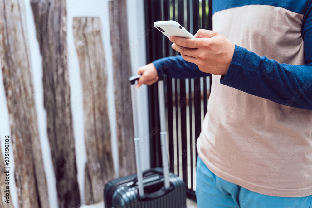 Obraz premium Traveler man with luggage case using smartphone.