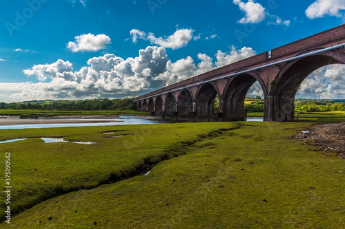 A view along the river bank towards the Hendy viaduct crossing the river Loughor at Pontarddulais, Wales in the summertime photo