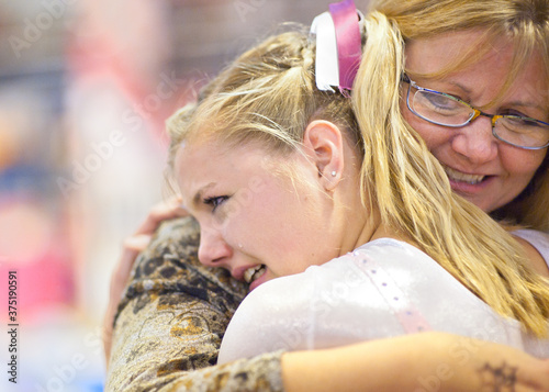 Mother hugs daughter after gymnastics performance photo