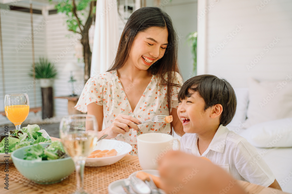 Asian mother and son eating healthy food together at restaurant. Asian mother and son eating healthy food together at restaurant.