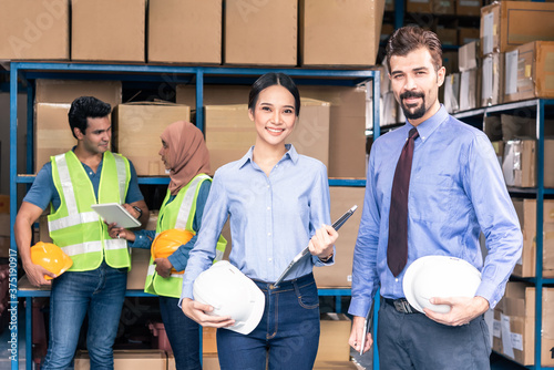 Boss and secretary with warehouse worker working in warehouse