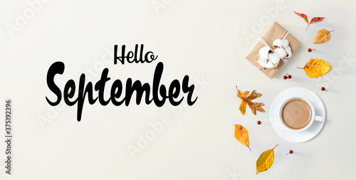Hello September message with autumn theme with coffee and gift box