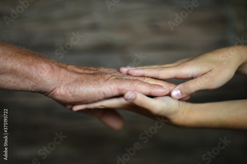 Man holding granddaughter's hand close up background