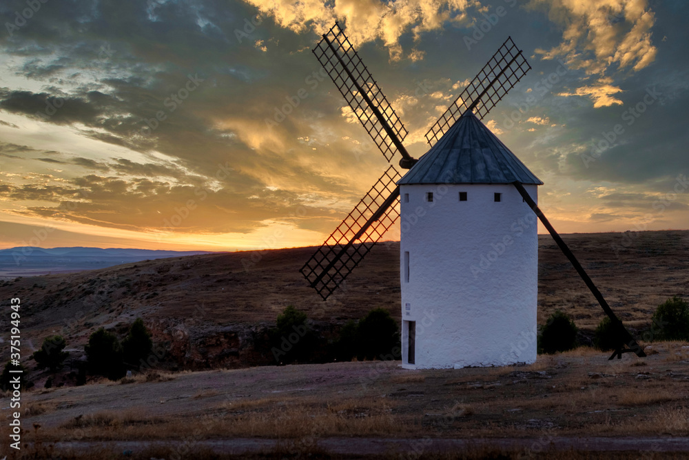 sunset of old spanish windmills on a sunny day with clouds