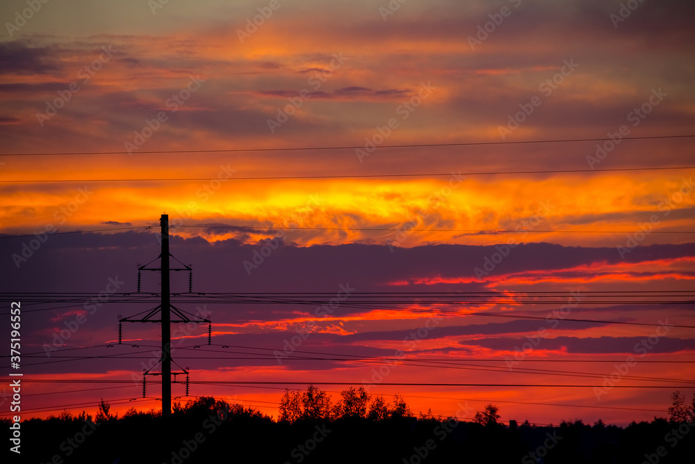 fiery sunset on the background of power lines