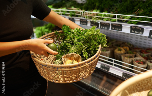 Woman Buying Fresh Fruit And Vegetables In Sustainable Plastic Free Grocery Store.