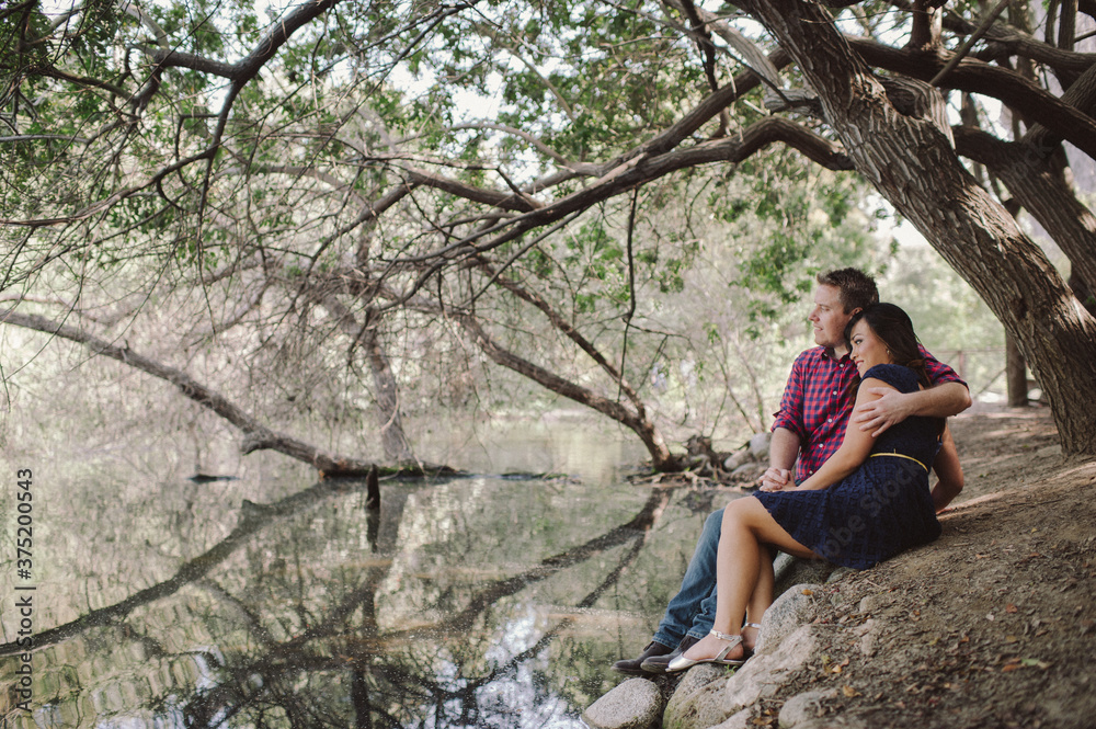 Romantic couple cuddling by lake in nature Romantic couple cuddling by lake in nature