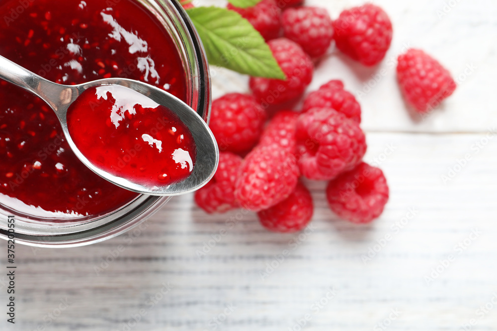 Sweet raspberry jam and fresh berries on white wooden table, flat lay Sweet raspberry jam and fresh berries on white wooden table, flat lay