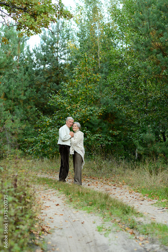 Portrait of senior couple walking in autumn forest © aletia2011